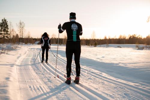 a man and woman cross country skiing in the snow at Snöå Bruk Hotell och konferens in Dala-Järna
