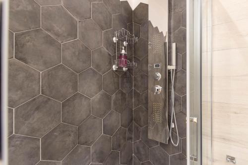 a bathroom with a shower with a hexagonal tile at Domu Ajaju Guest House in Villasimius
