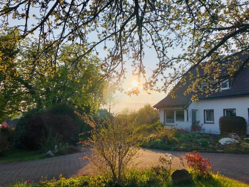 una casa con la puesta de sol en el fondo en Ferienwohnung mit Fernblick, en Hagen