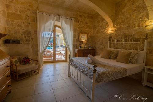 a bedroom with a bed in a stone room at Dar Tat Tork in Xagħra
