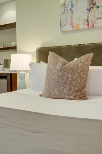 a bed with a silver pillow on top of it at Sojourn at DuPont Place in Washington