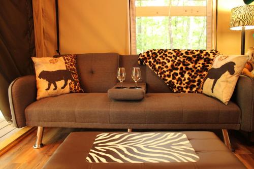 a living room with a brown couch with two wine glasses at Country Road Cabins in Hico