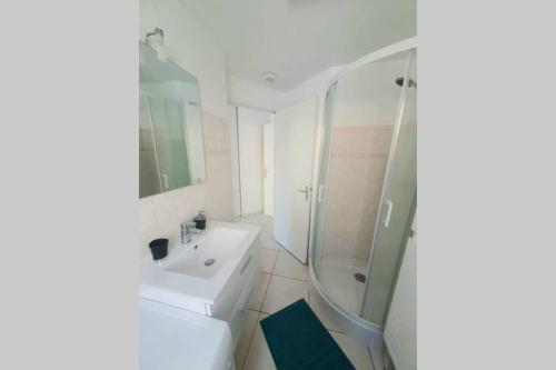 une salle de bain blanche avec une douche et un lavabo dans l'établissement Grand studio Nice Centre - bord de mer, à Nice