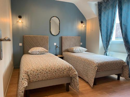 1 Schlafzimmer mit 2 Betten und einem Spiegel in der Unterkunft Entre Cher et Loire in Pontlevoy