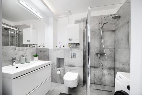 a bathroom with a shower and a toilet and a sink at Apartament AP30 in Mielno