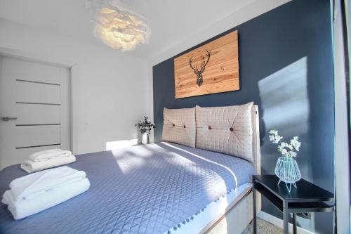 a bedroom with a bed with a blue wall at Apartament AP30 in Mielno