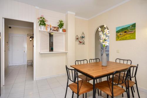 a dining room with a wooden table and chairs at Sant Mori in Empuriabrava