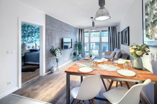 ミエルノにあるApartament AP4の木製のテーブルと白い椅子のあるダイニングルーム