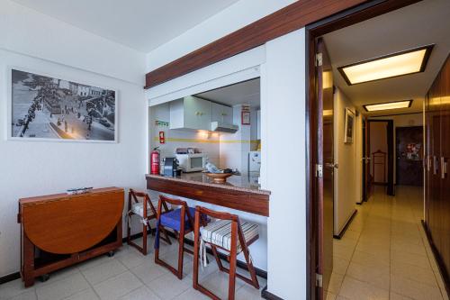a kitchen with a table and chairs in a room at House on the Beach in Sesimbra