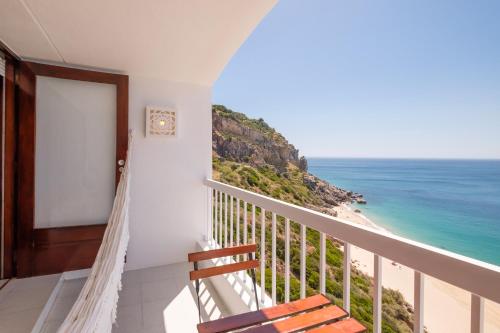 a room with a balcony with a view of the ocean at House on the Beach in Sesimbra
