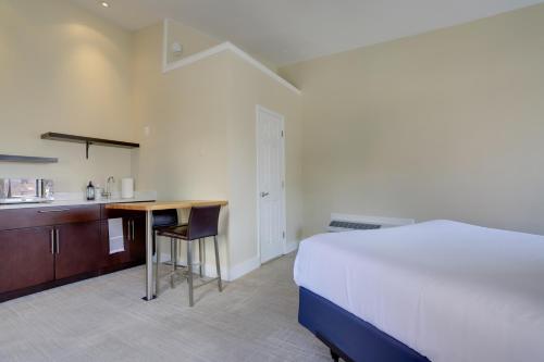a bedroom with a bed and a desk and a kitchen at Sojourn at DuPont Place in Washington