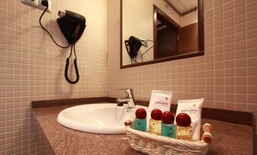 - Baño con lavabo y cesta de cerezas en Hostal Avenida Barajas, en Madrid