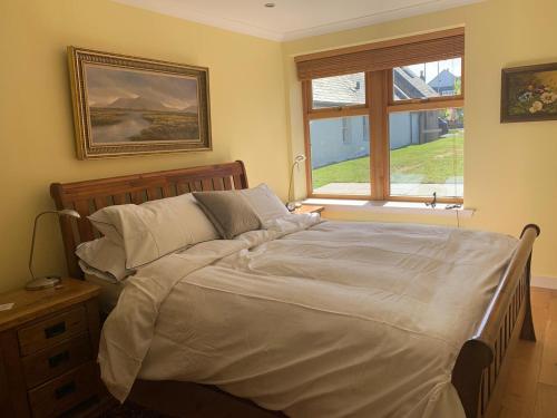 a large bed in a bedroom with a window at Abbey Cottage, Findhorn in Findhorn