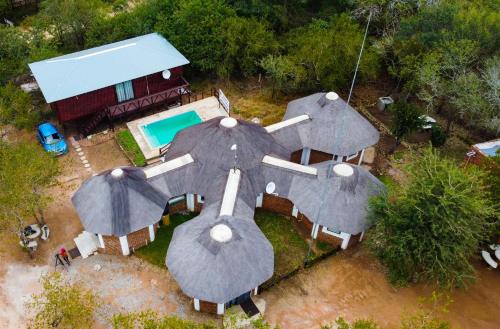 an aerial view of a house with a pool and umbrellas at Nanisto Bush Lodge in Marloth Park