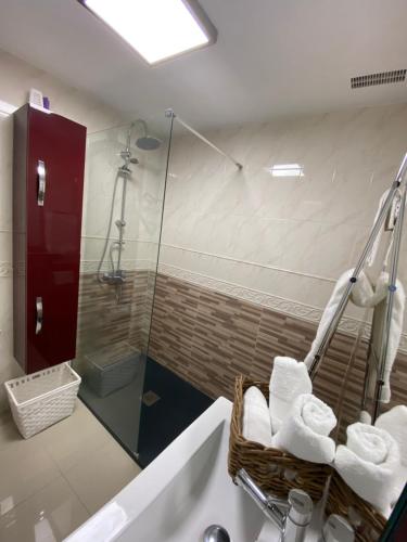 een badkamer met een douche, een bad en handdoeken bij Apartamento Centro Frente Muralla 2 in Lugo