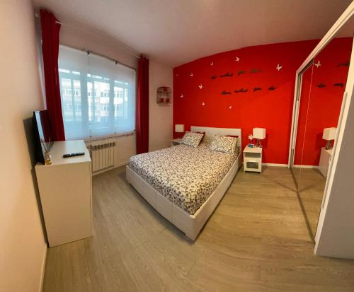1 dormitorio con cama y pared roja en Apartamento Centro Frente Muralla 2 en Lugo