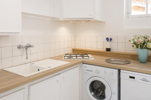 a kitchen with a washing machine and a sink at LES URSULINES Centre Historique de BAYEUX in Bayeux