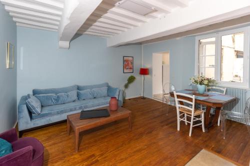 un salon avec un canapé bleu et une table dans l'établissement LES URSULINES Centre Historique de BAYEUX, à Bayeux