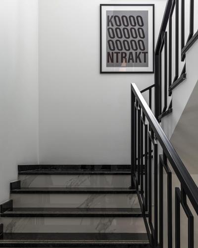 a staircase with black railings and a picture on the wall at KONTRAKT Boutique Hotel in Kyiv
