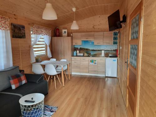 a kitchen and living room with a couch and a table at Domki przy jeziorze Wejsuny in Ruciane-Nida