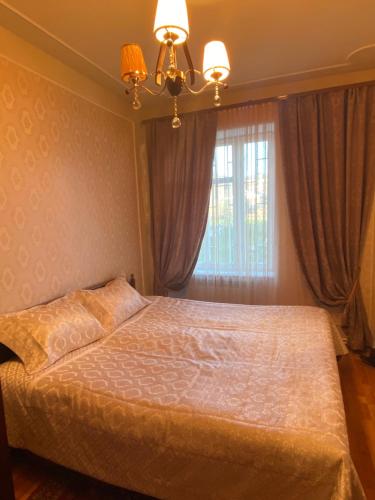 a bedroom with a bed with a chandelier and a window at Nina BNB in Sevan