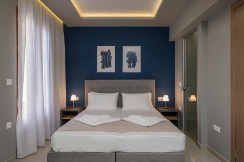 a bedroom with blue walls and a bed with two pillows at MIRMA CITY Old Town in Chania