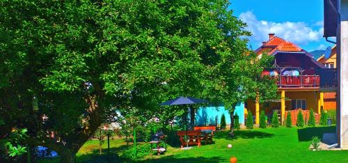 a house with a yard with a table and an umbrella at Guest house Dagovic in Bajina Bašta