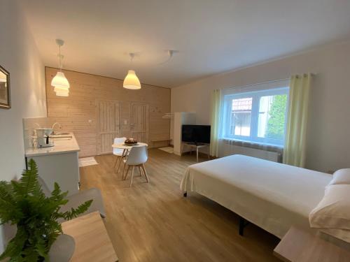 1 dormitorio con 1 cama blanca grande y cocina en Miły Apartament en Ustrzyki Dolne