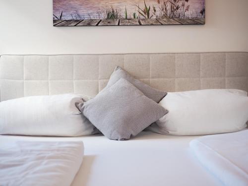 a pile of pillows sitting on top of a bed at Moderne Ferienwohnung mit Seeblick & Terrasse 96qm in Großräschen