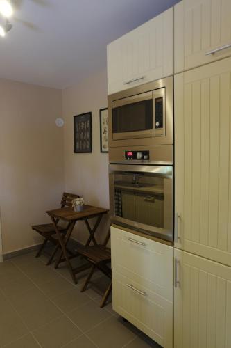 a kitchen with a microwave oven and a table at Kajári Apartmanház in Balatonfőkajár