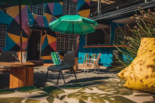 Habitación con sillas y mesa con sombrilla. en Social Hostel Café e Bar, en Curitiba