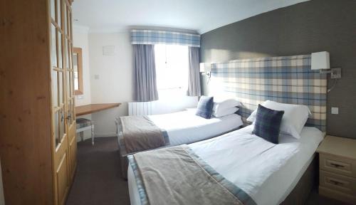 a hotel room with two beds and a window at Loch Rannoch Highland Lodge 44 in Kinloch Rannoch