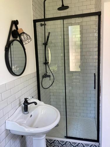 een badkamer met een wastafel en een douche bij Hôtel La Demeure Coloniale in Moriani Plage
