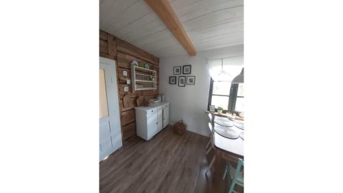 uma cozinha com armários brancos e pisos de madeira em Agroturystyka Banachy 50 em Harasiuki