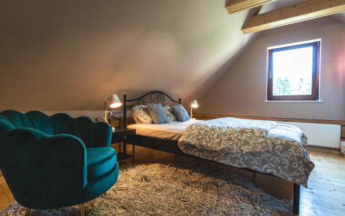 1 dormitorio con 1 cama y 1 silla azul en Apartamenty SPOKOLOKO Letniczówka Widoki, en Bystra