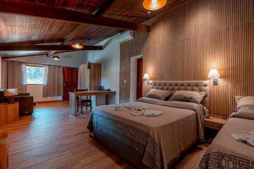 1 dormitorio con 2 camas y sala de estar en Hotel Fazenda Santa Barbara, en Engenheiro Paulo de Frontin
