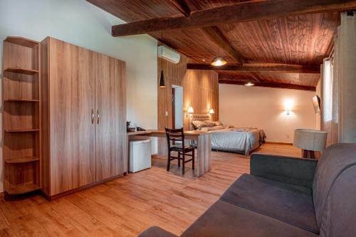 a bedroom with a bed and a desk in a room at Hotel Fazenda Santa Barbara in Engenheiro Paulo de Frontin