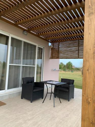 a patio with a table and chairs under awning at Marion Apartments in Kourouta
