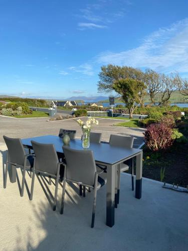 a table with chairs and a vase of flowers on it at Cill Bhreac House B&B in Dingle
