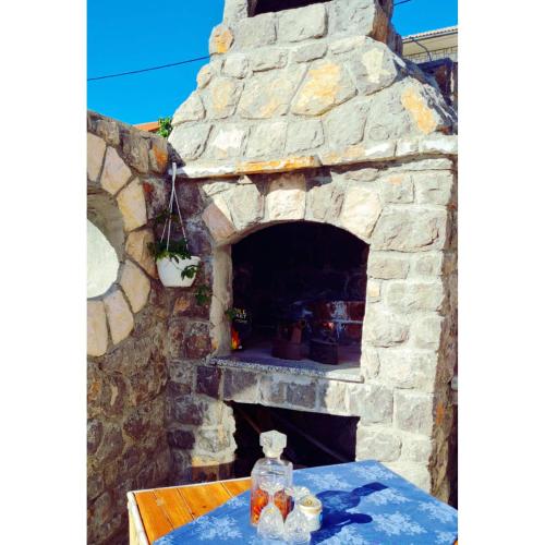 a stone oven with a table in front of it at Rooms Verda in Senj