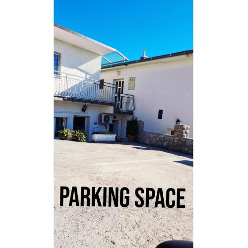 a white house with the words parking space at Rooms Verda in Senj