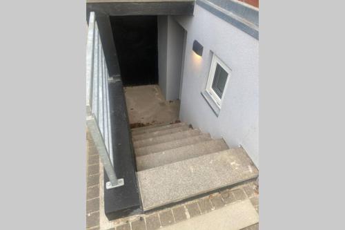 una escalera que conduce a la puerta de un edificio en Central kælder lejlighed en Give