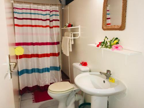 ein Badezimmer mit einem weißen WC und einem Waschbecken in der Unterkunft HUAHINE - Bungalow Pitate in Fare