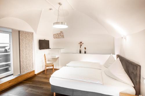 Schlafzimmer mit einem weißen Bett und einem Schreibtisch in der Unterkunft restaurant271 in Burghausen