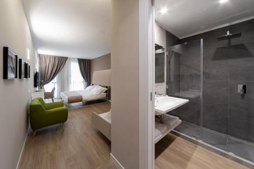 a bathroom with a shower and a sink and a bedroom at Alma Suites in Naples