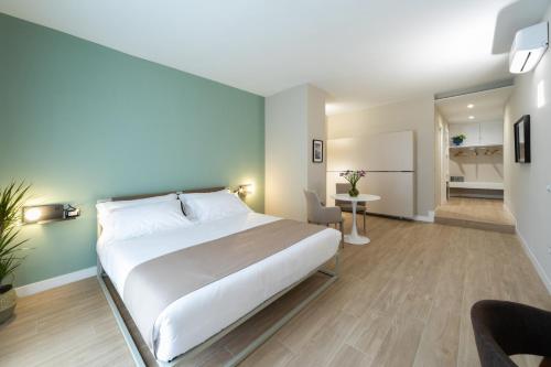 a bedroom with a large white bed and a desk at Alma Suites in Naples