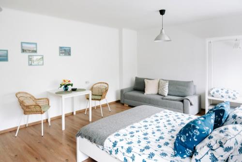 1 dormitorio con cama, sofá y mesa en Lake Aluksne studio apartment, en Alūksne