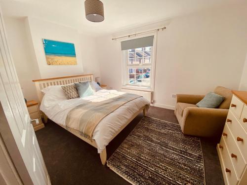 um quarto com uma cama, um sofá e uma janela em 3 Bed House with Garden near Weymouth Beach em Weymouth
