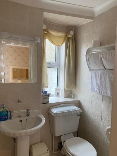 a bathroom with a white toilet and a sink at The Old Coach House in Blackpool