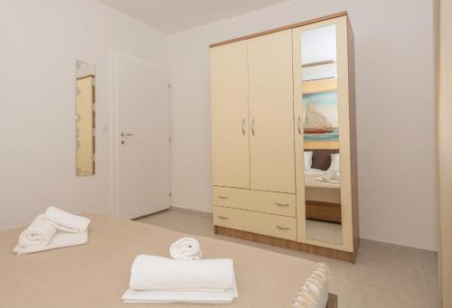 a room with a mirror and a bed with towels at Apartmani Vukusic in Promajna